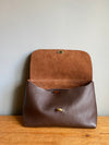 dark brown leather handbag shown with flap open so the interior can be seen