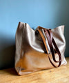 Rose gold leather tote bag with shoulder straps and top zip