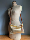 Gold leather crossbody handbag with zipped exterior pocket by Ginger and Brown shown on a vintage tailors dummy.