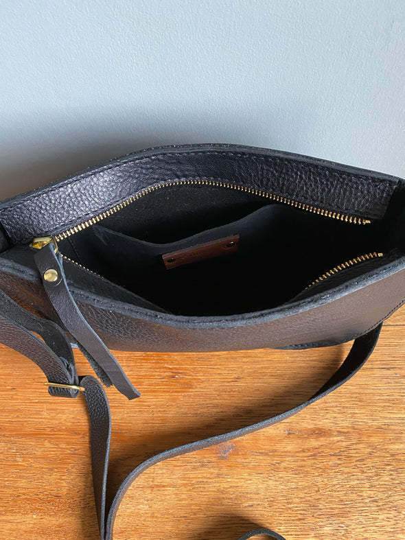 interior shot of a black leather crossbody handbag