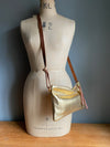 Gold leather crossbody handbag with zipped exterior pocket by Ginger and Brown shown on a vintage tailors dummy.