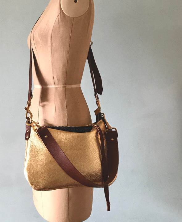 gold leather handbag with crossbody strap and shoulder strap