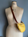 Yellow crossbody bumbag modelled by a vintage dressmaking dummy