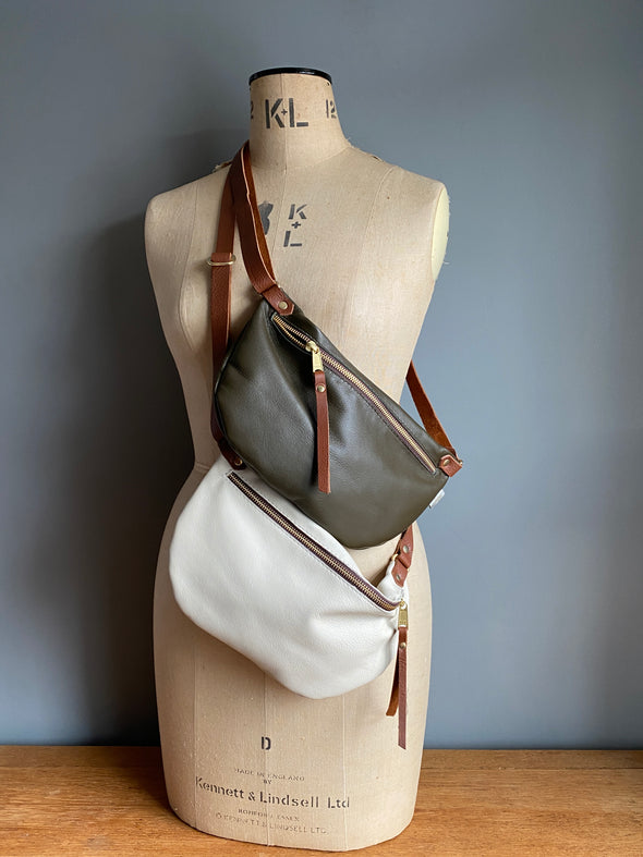 Dark Olive and Clotted Cream Ryder Half Moon bag, leather travel bags on a vintage dressmakers dummy