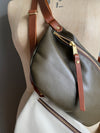 Dark Olive and Clotted Cream Ryder Half Moon bag, leather travel bags on a vintage dressmakers dummy