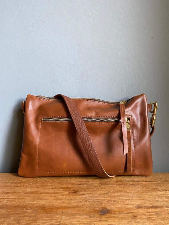 Crossbody handbag in tan brown leather with zipped exterior pocket and adjustable crossbody strap by Ginger and Brown 