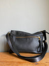 Crossbody handbag in black leather with zipped exterior pocket and adjustable crossbody strap by Ginger and Brown.