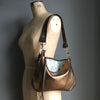 Bronze leather purse with shoulder strap shown on a vintage tailor's dummy